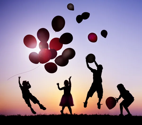 Niños al aire libre jugando globos —  Fotos de Stock