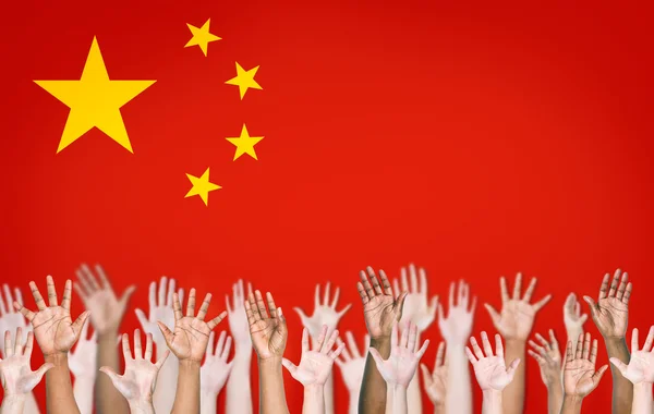 Mãos levantadas com bandeira chinesa — Fotografia de Stock