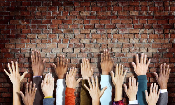Hands Raised on Brick Wall — Stock Photo, Image