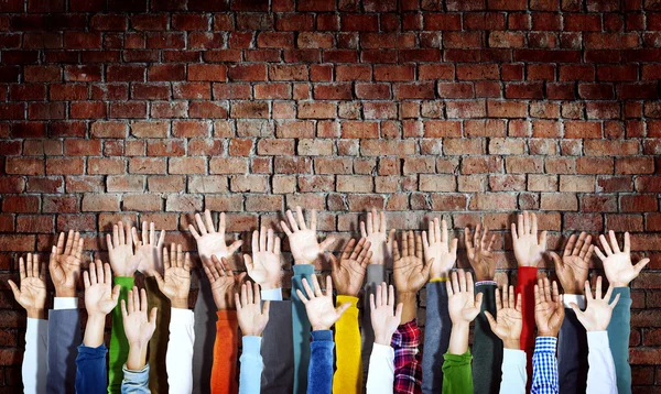 Mâinile ridicate pe peretele de cărămidă — Fotografie, imagine de stoc