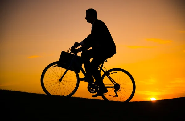 Uomo d'affari in bicicletta sulla collina — Foto Stock