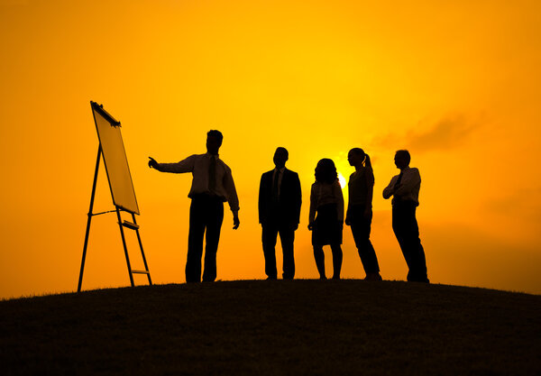 Business Meeting on hill at sunset