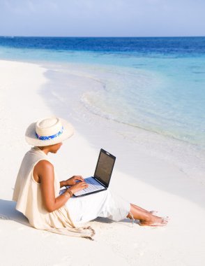 laptop sahilde bir kadınla