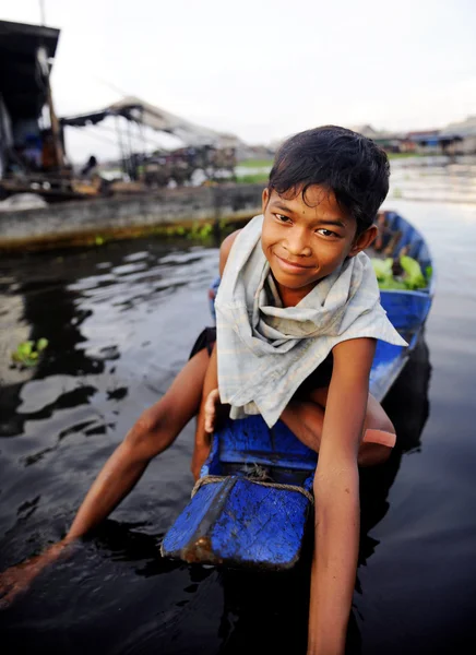 Boy traveling by boat in floating village — Stock Photo, Image