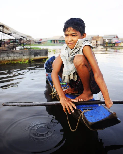 Junge mit Boot in schwimmendem Dorf unterwegs — Stockfoto