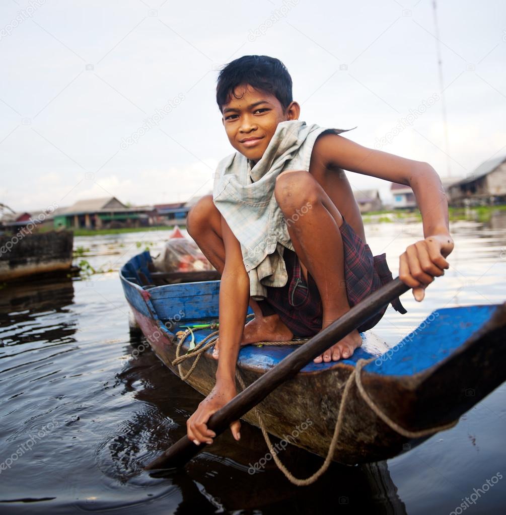 Boy traveling by boat in floating village