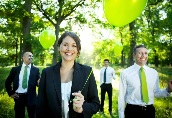 Empresários segurando balões verdes — Fotografia de Stock