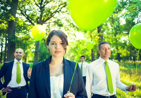 Gente de negocios sosteniendo globos verdes —  Fotos de Stock