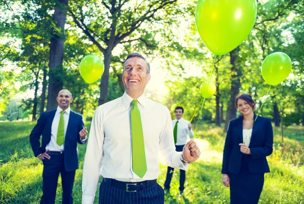 Business folk anläggning gröna ballonger — Stockfoto
