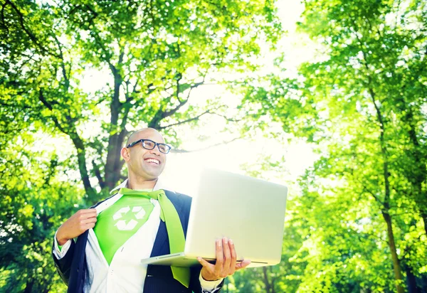 Businessman holding laptop in forest — Stock Photo, Image