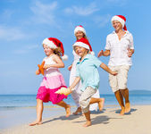 Rodina na pláži v vánoční čepice