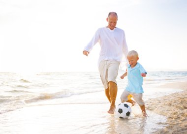 Baba oğul futbol oynuyor.
