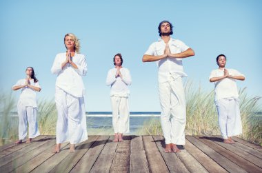 Bir grup insan plajda Yoga yaparken