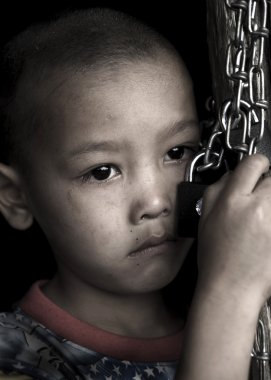 Bir kilit ve zincir clasping üzgün çocuk