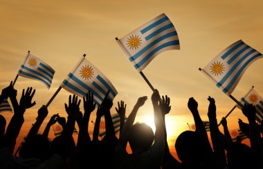 Arjantin bayrakları tutan insanlar