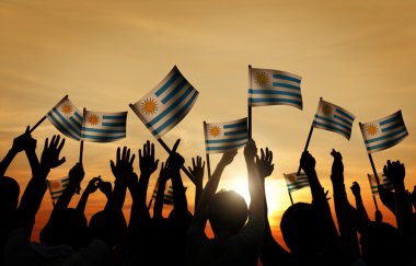 İnsanlar Uruguaylı bayrakları sallayarak
