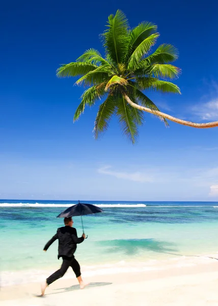 Businessman running at beach — Stock Photo, Image