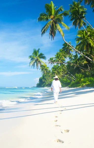 Женщина, гуляющая по тропическому пляжу — стоковое фото