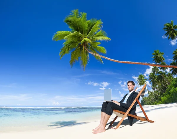 Empresario trabajando en portátil en la playa — Foto de Stock