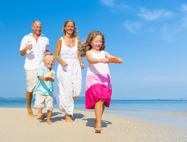 Familia corriendo en la playa — Foto de Stock