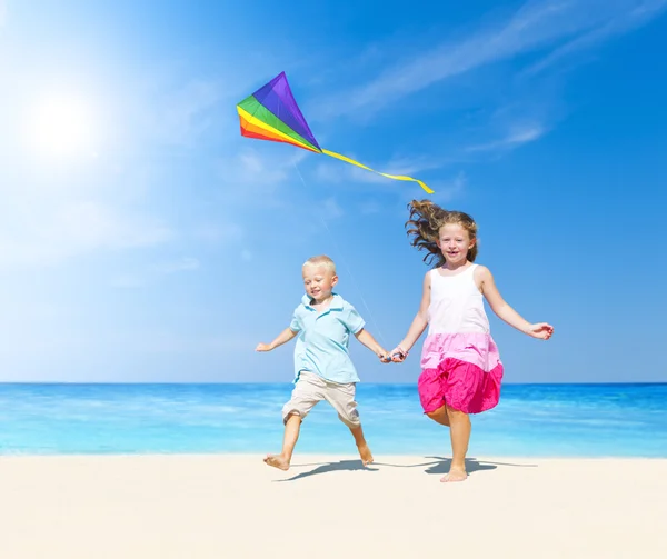 Frère et sœur jouant sur la plage — Photo