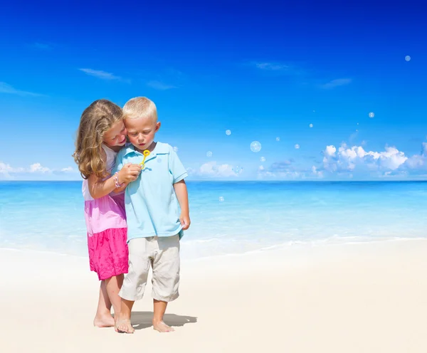 Брат і сестра грають на пляжі. — стокове фото