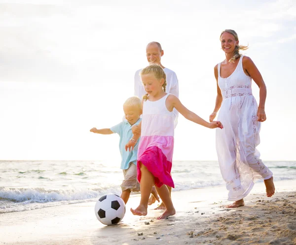 Family playing football on beach — Stock Photo, Image