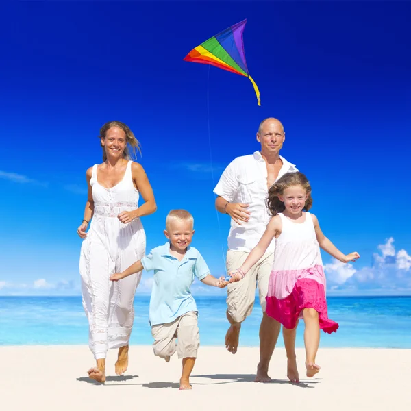 Famiglia in esecuzione sulla spiaggia — Foto Stock