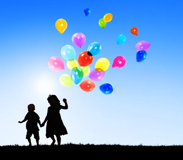 Niños al aire libre sosteniendo globos —  Fotos de Stock