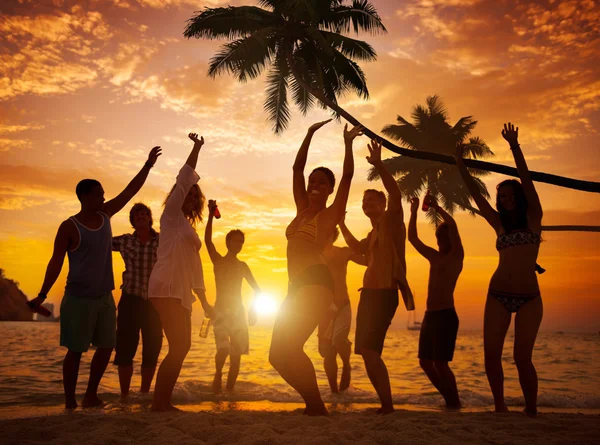Pessoas dançando e festejando em uma praia tropical — Fotografia de Stock