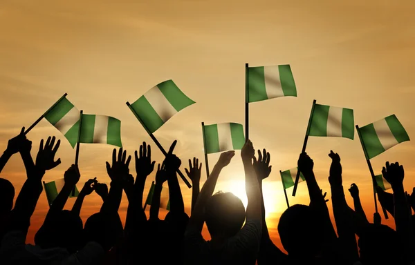 Menschen schwenken Fahnen Nigerias — Stockfoto