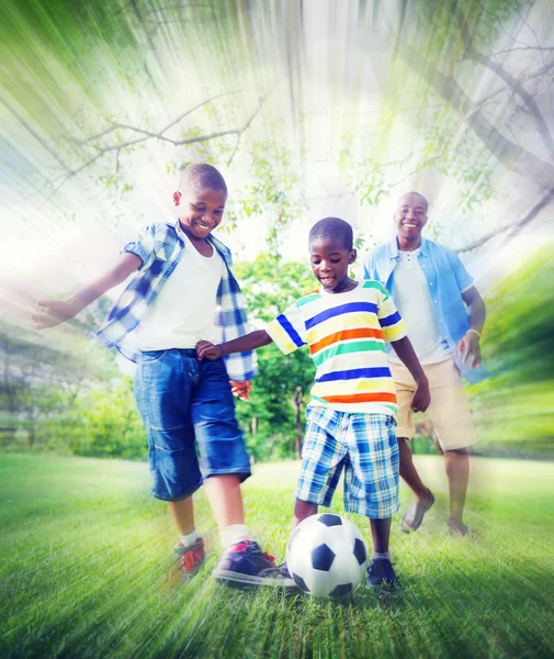 Pai e filhos jogando futebol ao ar livre — Fotografia de Stock