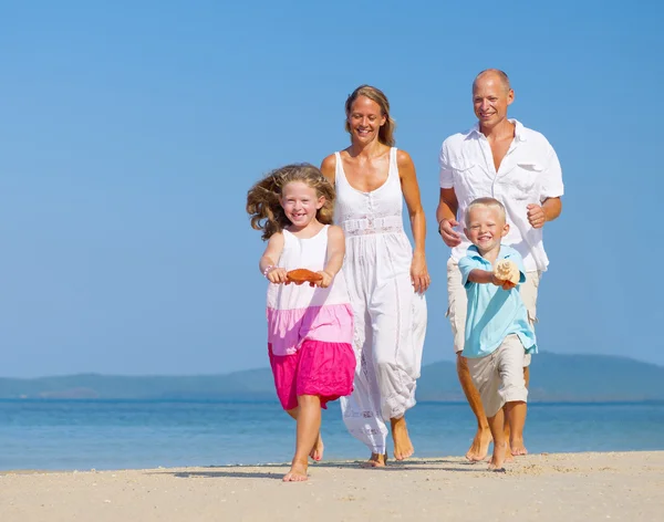 Familia corriendo en la playa Imagen De Stock