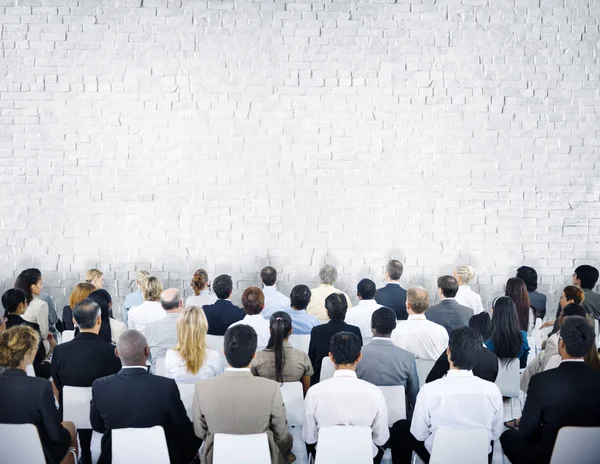 Grupp av publiken med tegelvägg — Stockfoto