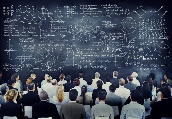 People with Formulas on Chalkboard — Stock Photo, Image