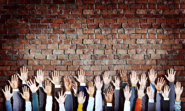 Mãos diversas levantadas — Fotografia de Stock