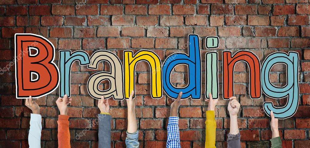 Multiethnic Group of Hands Holding Word Branding isolated on brick background