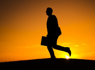 Günbatımı önünde çalışan iş adamı