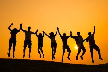 İnsanlar gün batımında başarı kutluyor