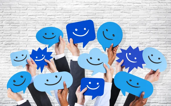 Hands holding smiley faces — Stock Photo, Image