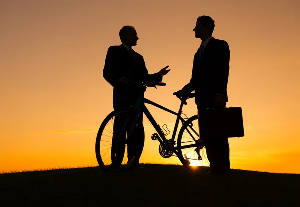 Businessmen are talking to each other with bicycle — Stock Photo, Image