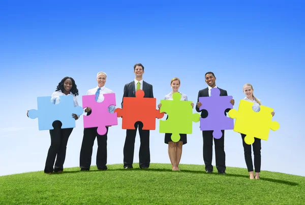 Business people holding puzzle pieces — Stock Photo, Image