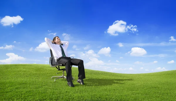 Businessman relaxing on the field — Stock Photo, Image