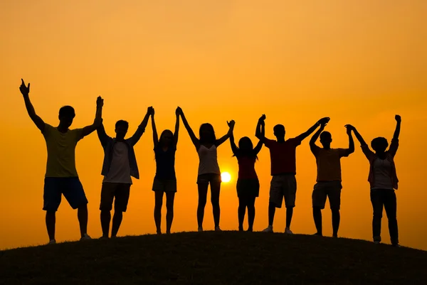 Gente celebrando el éxito al atardecer — Foto de Stock