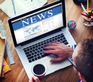 Dizüstü bilgisayar ile Global News kullanan adam