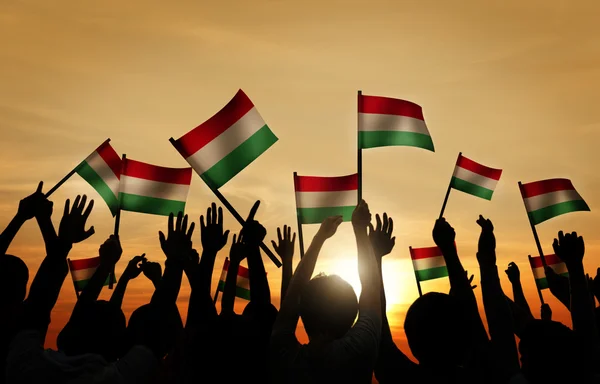 Lidé drží vlajky Maďarska — Stock fotografie