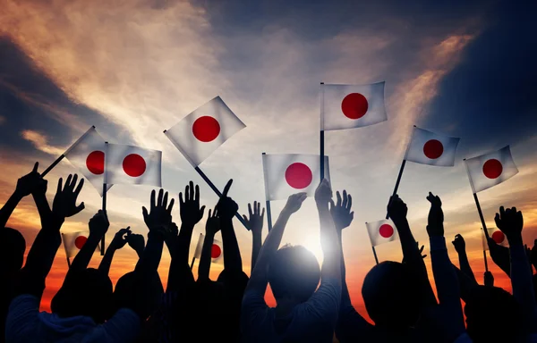 Les gens qui tiennent les drapeaux du Japon — Photo