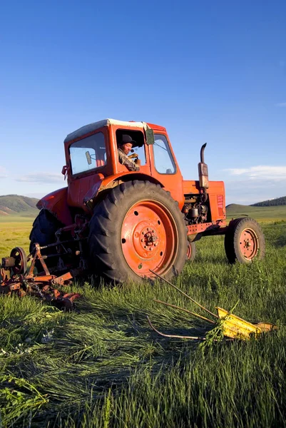 农民在球场上驾驶他的拖拉机 — 图库照片