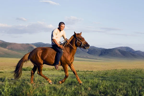 Joven montando un caballo — Foto de Stock