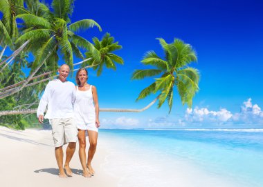 Kumsalda yürüyen bir çift.